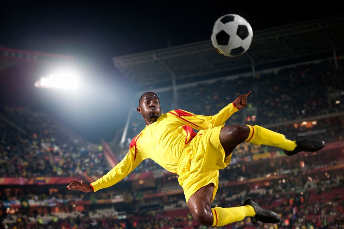 Futbolista golpeando balón en el aire