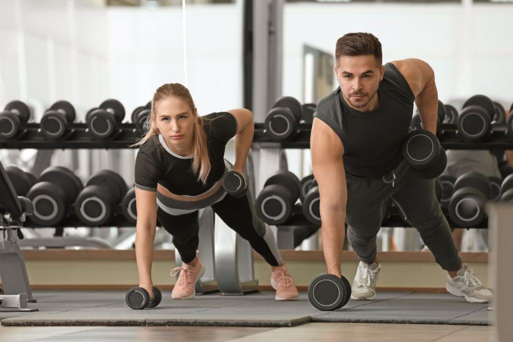 Hombre y mujer entrenando con pesas